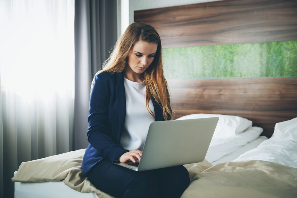 business woman in modern hotel room sitting on bed BGYR5GC