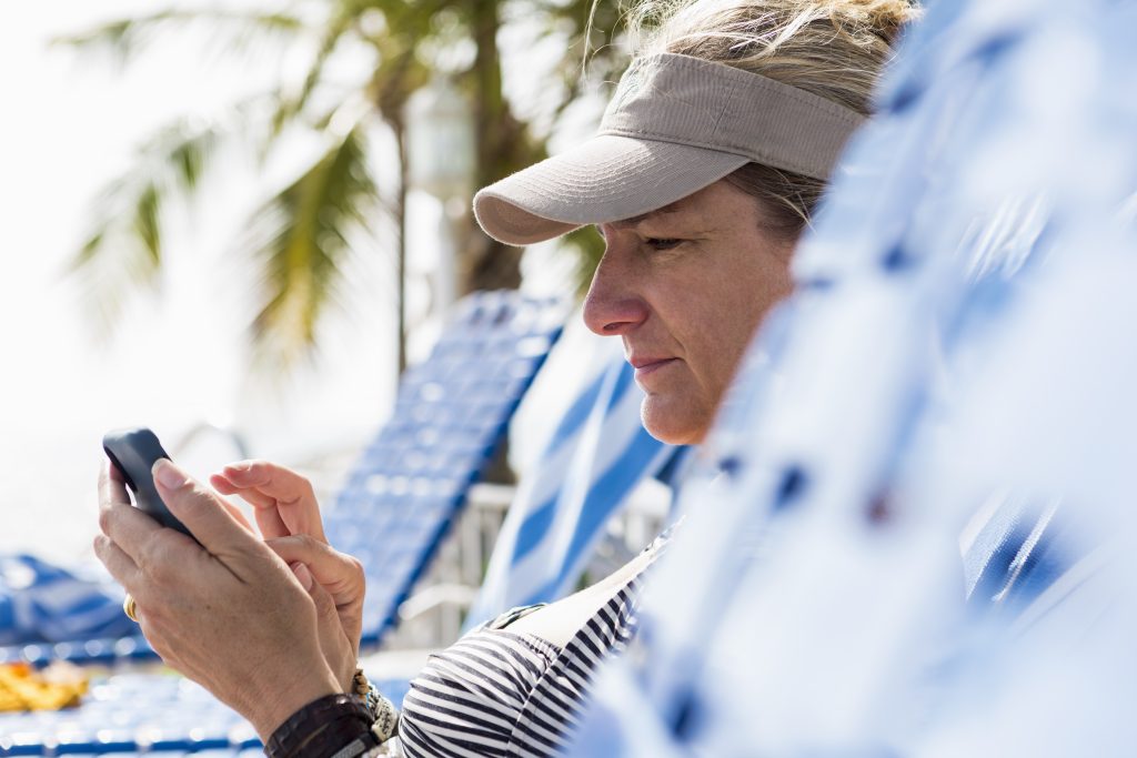 woman texting on smart phone on vacation LR8ZPSF