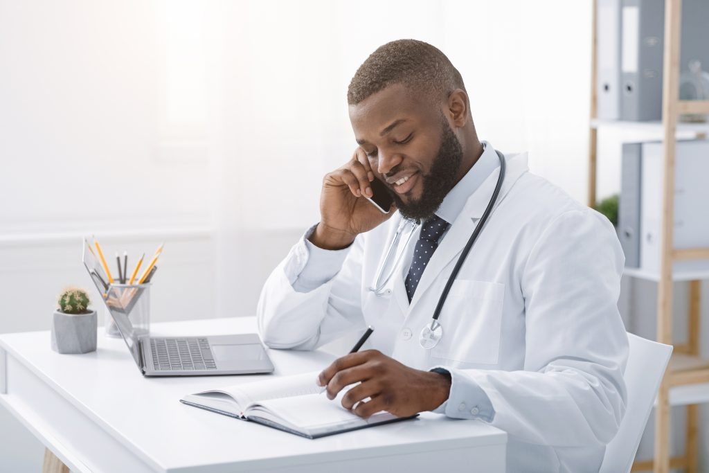 young african doctor talking to patient on phone LDZHNPX